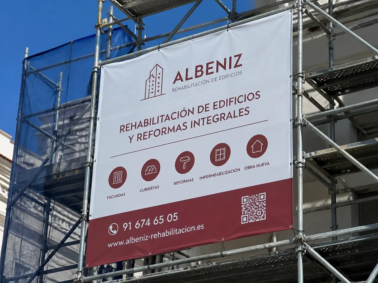 Lona publicitaria impresa de gran formato instalada en el andamio de una obra en Alicante